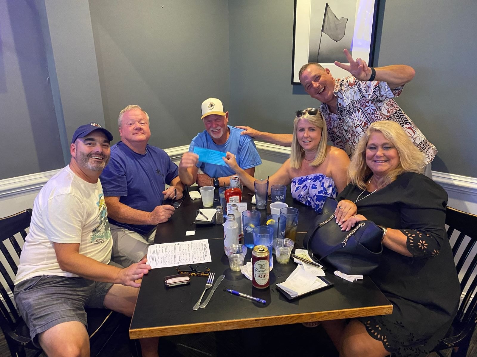 A smiling team gathered around a table with game sheets